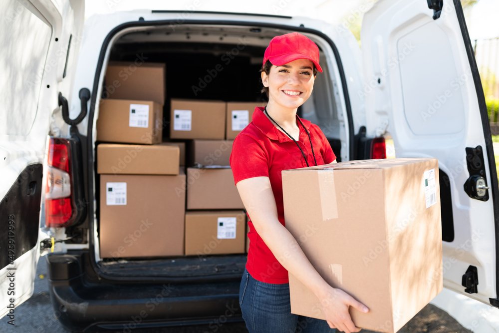 Female courier and driver carrying a bunch of packages